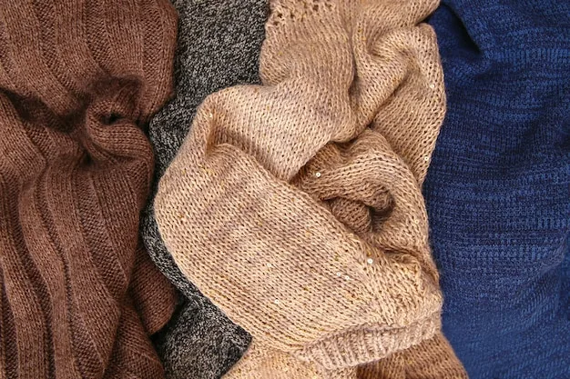 A close-up of various winter wardrobe essentials, including a merino wool base layer, a cashmere sweater, a down vest, and a waterproof jacket. The image is focused on the textures and materials that are ideal for layering and staying warm in winter, highlighting The Art of Layering: A Style Guide for Staying Warm and Stylish All Winter.