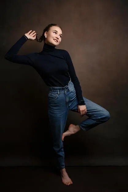 A model with an hourglass figure wearing high-rise, dark wash flare jeans and a fitted black top. The jeans accentuate her waist and create a balanced silhouette.