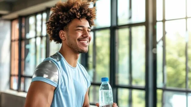 A person smiling and drinking water after finishing an exercise routine, highlighting the importance of hydration during Exercise for Beginners: A Simple 30-Day Plan to Improve Your Fitness.