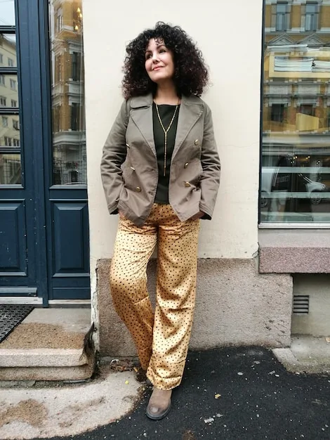 A model wearing a mixed print top and skirt, paired with a solid-colored trench coat. The trench coat acts as a neutral ground, balancing the boldness of the prints and creating a cohesive look. The overall styling is sophisticated and demonstrates how a neutral element can enhance a mixed print outfit. This showcases another aspect of The Ultimate Guide to Mixing Prints: 3 Rules for Creating Stylish Outfits.