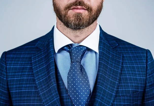 A close-up shot of a well-dressed man's torso, featuring a crisp white dress shirt, a subtly patterned silk tie, and a sharp navy blazer, highlighting the impeccable fabric and fit.