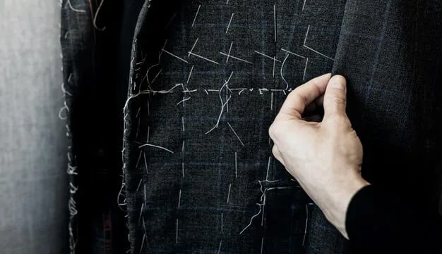 A close-up shot of hands inspecting the stitching on a classic wool blazer, emphasizing the high-quality craftsmanship and material. The fabric has a subtle texture.