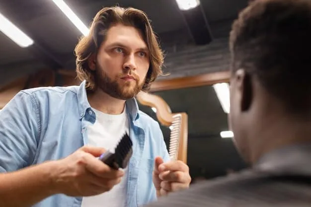 A man getting a professional haircut in a barber shop, illustrating attention to detail and hair shaping.