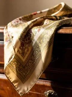 Authentic vintage silk scarf with classic pattern on antique dresser