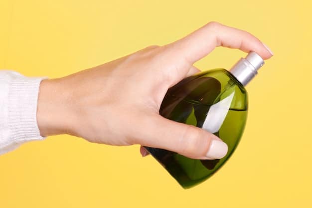 A close-up shot of a hand gently holding a perfume bottle made from recycled glass. The background is blurred, showcasing a green, lush garden, emphasizing the theme of natural and sustainable fragrance ingredients.