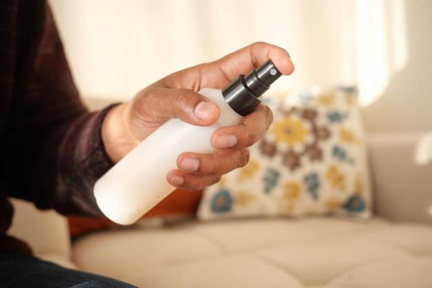 A person spraying perfume on their wrist, with a blurred background of a cozy, well-lit room. Focus on the hand and the mist of the spray.
