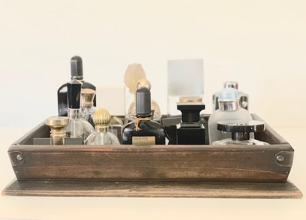 A visually captivating photo of various perfume bottles arranged on a table, with perfume atomizers spraying a mist of fragrance upwards, creating a dynamic and artistic effect. The background is softly blurred, emphasizing the sensory experience of smelling perfume.