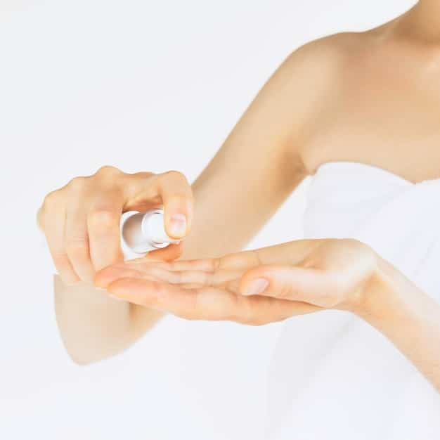 A close-up shot of a person's wrist, lightly sprayed with a fragrance. The skin shows delicate texture, and tiny droplets of the perfume are visible, catching the light. The background is softly blurred, creating a sense of intimacy and personal experience.