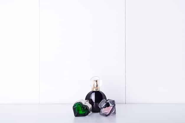 A photograph of several popular perfume bottles arranged on a white marble countertop. The perfumes vary in shape and color, showcasing a range of fragrances. Soft, natural light illuminates the scene, highlighting the elegant designs of the bottles.