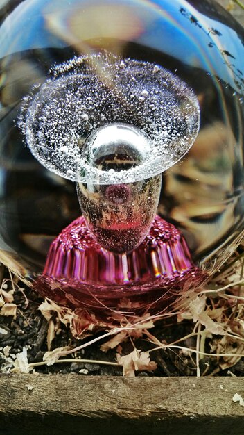 An artistic arrangement of fragrance atomizers spraying various scents into the air, creating a visible mist of layered fragrances. The background is a blurred, minimalist setting, highlighting the act of layering scents and the visual representation of fragrance blending.