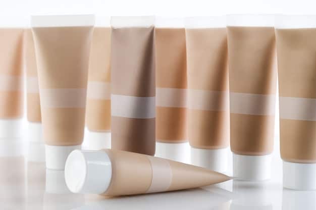 A photograph displaying a variety of dewy foundations. The bottles and compacts are arranged neatly on a clean surface, highlighting differences in textures and shades. The lighting enhances the radiant quality of the products, with labels clearly visible indicating their hydrating formulas.