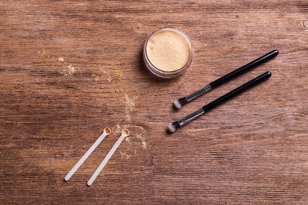 A selection of nose contouring products laid out on a table, including contour sticks, powder palettes with different shades, highlighting creams, and various makeup brushes designed for precise application and blending.