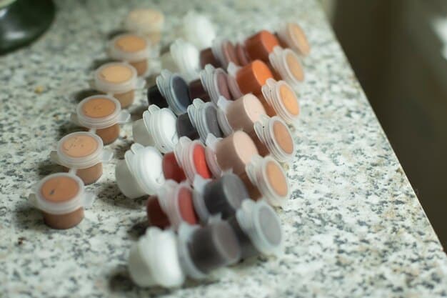 A close-up of various foundation formulas displayed on a makeup counter, including liquid, powder, cream, and stick foundations. Each is labeled clearly, showcasing the variety available. The background is a professional makeup studio setup with brushes and other cosmetics.