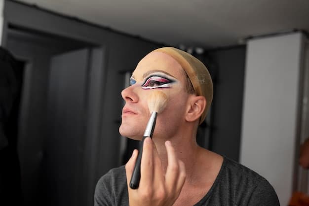 A close-up of a makeup artist applying a light, shimmering eyeshadow to the brow bone and inner corner of a model's eye, highlighting the areas and blending seamlessly with the transition shade.