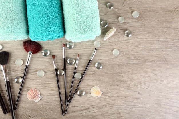 A top-down view of clean makeup brushes laid out on a clean white towel, drying in a well-lit area of a bathroom.