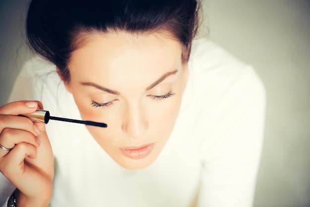 A woman demonstrating the vertical mascara application technique, focusing on using the tip of the wand to coat individual lashes for defined separation.