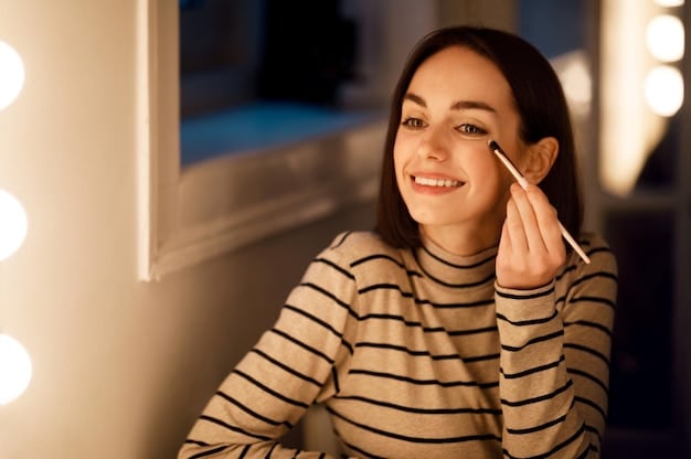 A woman applying silver glitter eyeshadow to her eyelid with a makeup brush, with a focused expression and soft lighting.