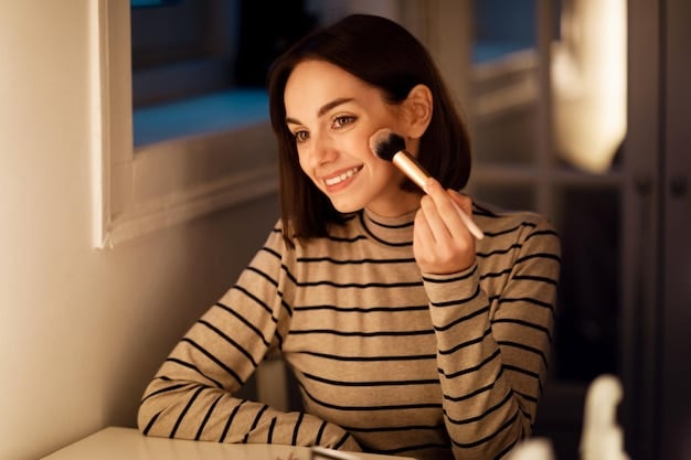 Close-up of a woman applying highlighter to her cheekbones with a makeup brush. The light catches the shimmer, creating a subtle, radiant glow. Fine lines and pores are minimized, showcasing a smooth and luminous complexion.