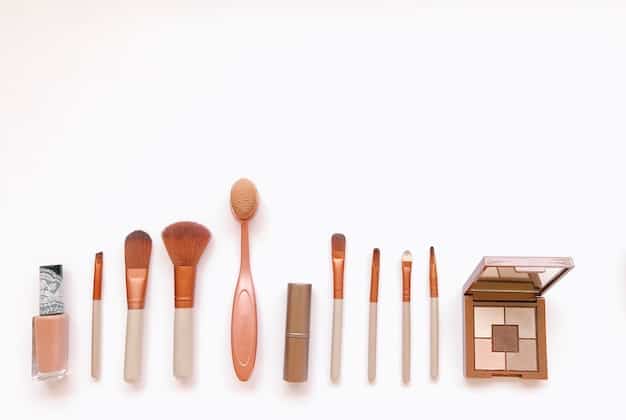 A collection of makeup brushes laid out on a white surface. There are several bronzer brushes, characterized by their large, fluffy heads, and a few smaller, tapered highlighter brushes. The brushes are clean and well-maintained, showcasing their importance in achieving a flawless makeup application.
