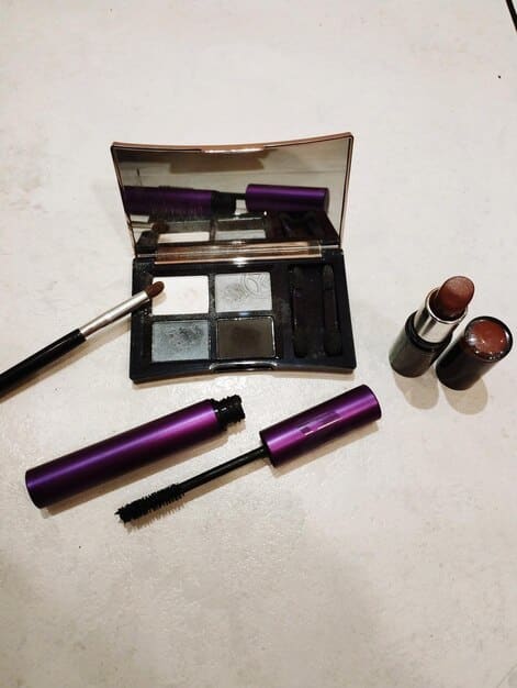 An organized makeup station with essential smoky eye products: eyeshadow palette with neutral and dark shades, blending brushes, eyeliner pencil, mascara, and concealer.