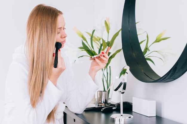 A woman applying red lipstick with a lip brush in front of a mirror. She is carefully lining her lips, focusing on precision. The background shows a well-lit vanity with various makeup products.