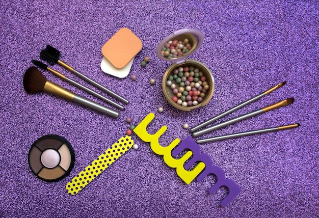 A close-up shot of a variety of eyeshadow brushes laid out on a surface, showcasing different shapes and sizes, some with product on them and others clean.