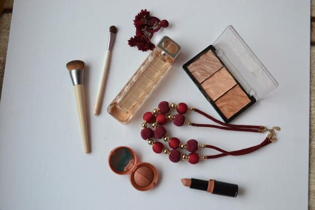 A collection of various makeup products laid out on a vanity, including primer, foundation, setting spray, glittery eyeshadow, and a bold red lipstick. The products are arranged neatly, suggesting a well-organized and prepared makeup routine.