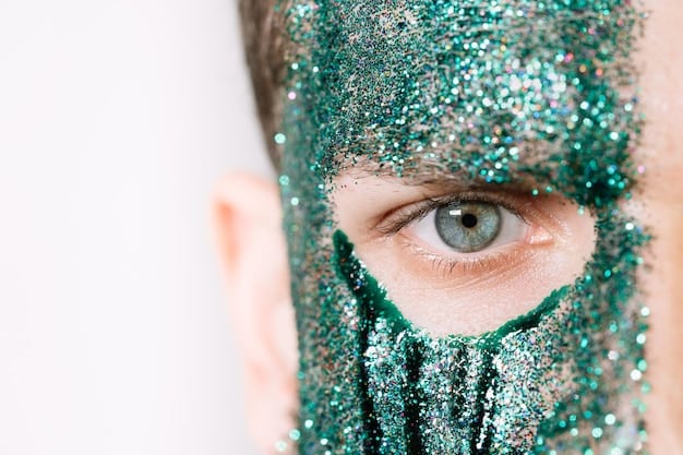 A detailed close-up of a woman’s eye with intricate holiday-themed eyeshadow, featuring gold and green glitter, a precise black eyeliner wing, and long, voluminous eyelashes.