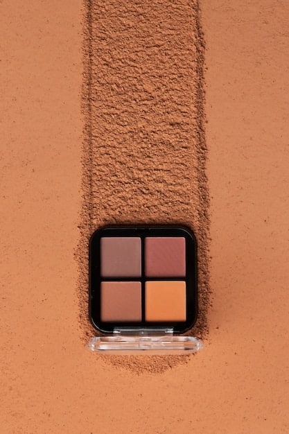 A close-up shot of an open eyeshadow palette featuring warm-toned shades such as browns, coppers, oranges, and golds. The palette should look well-used, indicating that these are favorite and frequently used colors.