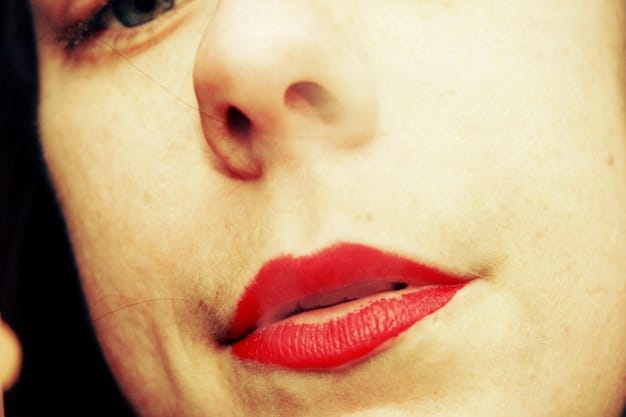 Close-up of a woman's lips with a bold red lipstick and a layer of fine gold glitter. The glitter is evenly distributed, creating a shimmering effect. The skin around the lips is smooth and highlighted.