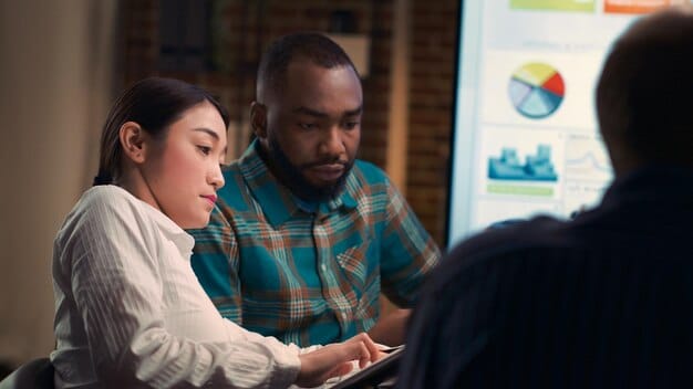 A diverse group of people looking concerned while looking at multiple digital screens displaying financial charts and data, symbolizing consumer anxiety over economic shifts.