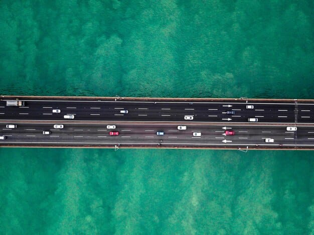 An aerial shot of a modern, well-maintained highway interchange with cars flowing smoothly, illustrating efficient infrastructure and economic movement. The image should convey progression and connectivity.