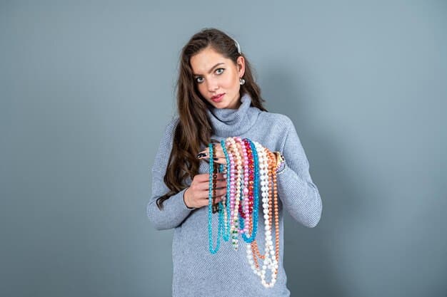 A person thoughtfully selecting an accessory from a small, curated collection of jewelry, belts, and scarves, demonstrating the power of accessories in a capsule wardrobe.