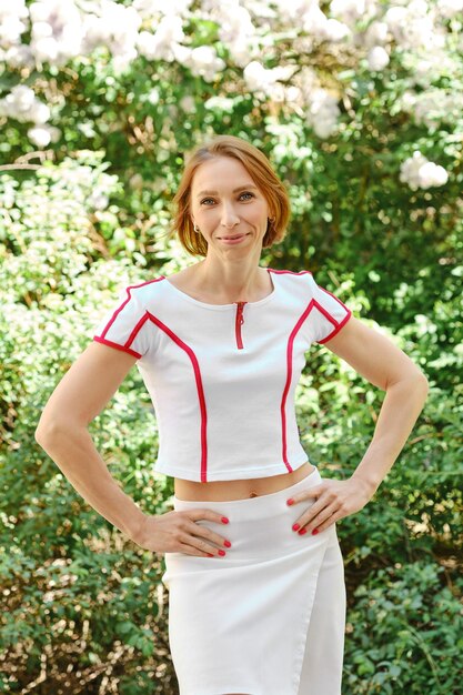 A woman with a rectangle body shape wearing a stylish peplum top paired with a flowing A-line skirt, creating the illusion of curves. She stands confidently with a slight smile.