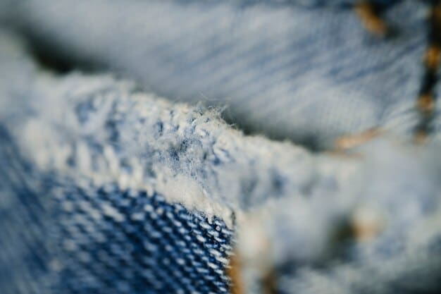 A close-up of different fabric textures in a layered outfit, showing a blend of knit, denim, and cotton, emphasizing the tactile elements of layering.