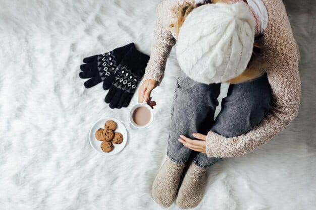 A cozy winter scene with a person bundled in multiple warm layers, including a chunky knit sweater, a thick scarf, and a stylish puffer coat, highlighting warmth and comfort.