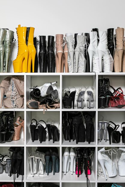 A neatly organized shoe rack showcasing a range of footwear, from classic black dress shoes and high heels to casual sneakers and comfortable loafers, illustrating versatility.