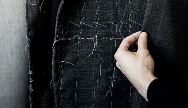 A close-up shot of hands inspecting the stitching on a classic wool blazer, emphasizing the high-quality craftsmanship and material. The fabric has a subtle texture.