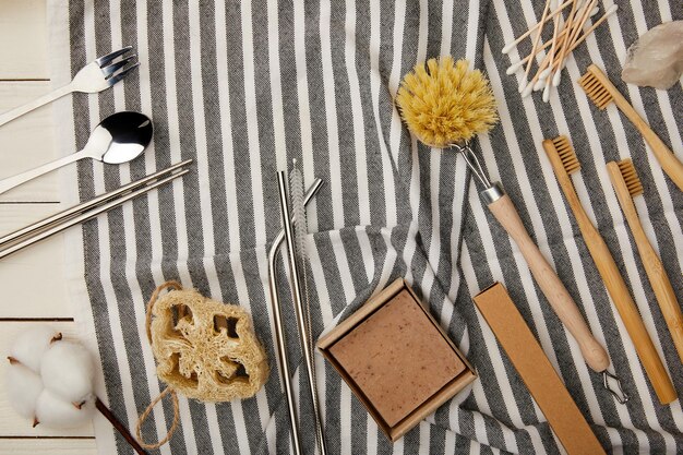 A detailed flat lay of various jewelry cleaning tools and solutions, including a soft cloth, a jewelry brush, and small jars of cleaning liquid, artfully arranged on a clean, light-colored surface, demonstrating proper care.