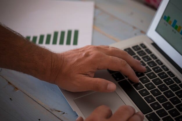 A close-up of hands working on a laptop, surrounded by scattered economic reports and charts, symbolizing in-depth data analysis and research for job market trends.