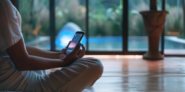 A person's hand holding a smartphone with a meditation app open, displaying a calm, blue interface. In the background, there's a subtle blur of a peaceful indoor setting.