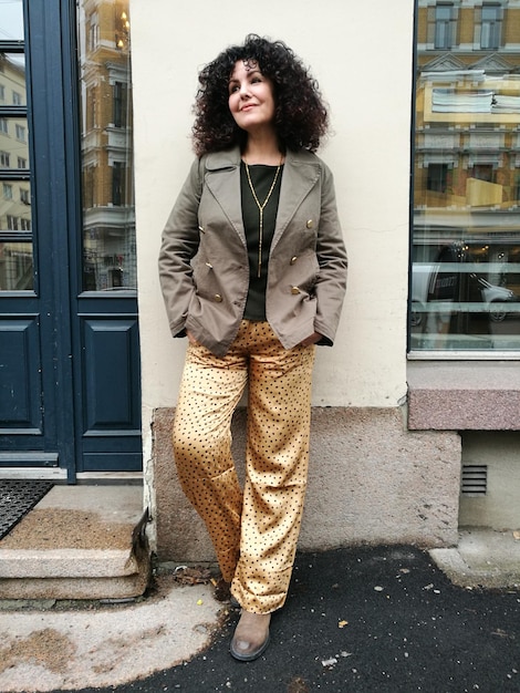 A model wearing a mixed print top and skirt, paired with a solid-colored trench coat. The trench coat acts as a neutral ground, balancing the boldness of the prints and creating a cohesive look. The overall styling is sophisticated and demonstrates how a neutral element can enhance a mixed print outfit. This showcases another aspect of The Ultimate Guide to Mixing Prints: 3 Rules for Creating Stylish Outfits.