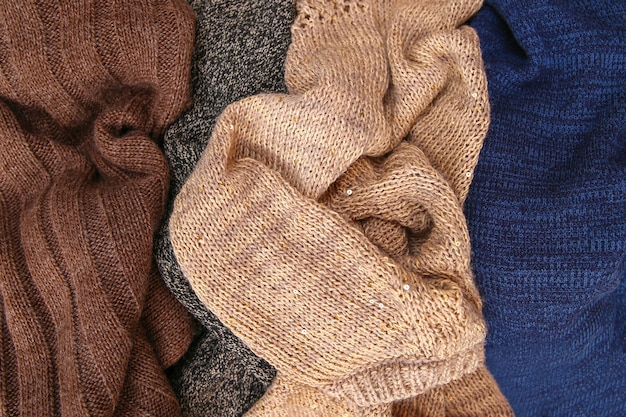 A close-up of various winter wardrobe essentials, including a merino wool base layer, a cashmere sweater, a down vest, and a waterproof jacket. The image is focused on the textures and materials that are ideal for layering and staying warm in winter, highlighting The Art of Layering: A Style Guide for Staying Warm and Stylish All Winter.