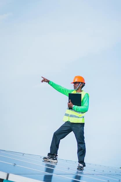 A technician wearing safety gear is installing solar panels on a rooftop, with a clear blue sky in the background. The image emphasizes the growth and opportunity within the renewable energy sector, which benefits from the increase in green initatives. The scene aims to visually encapsulate a key finding from the comprehensive 