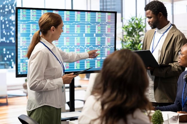 A diverse group of people in an office setting collaboratively analyzing charts and graphs on a large screen, representing economic data analysis and financial forecasting.