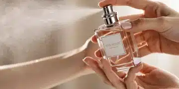 Person applying luxury perfume to their wrist, highlighting the personal experience of a premium fragrance.