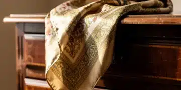 Authentic vintage silk scarf with classic pattern on antique dresser